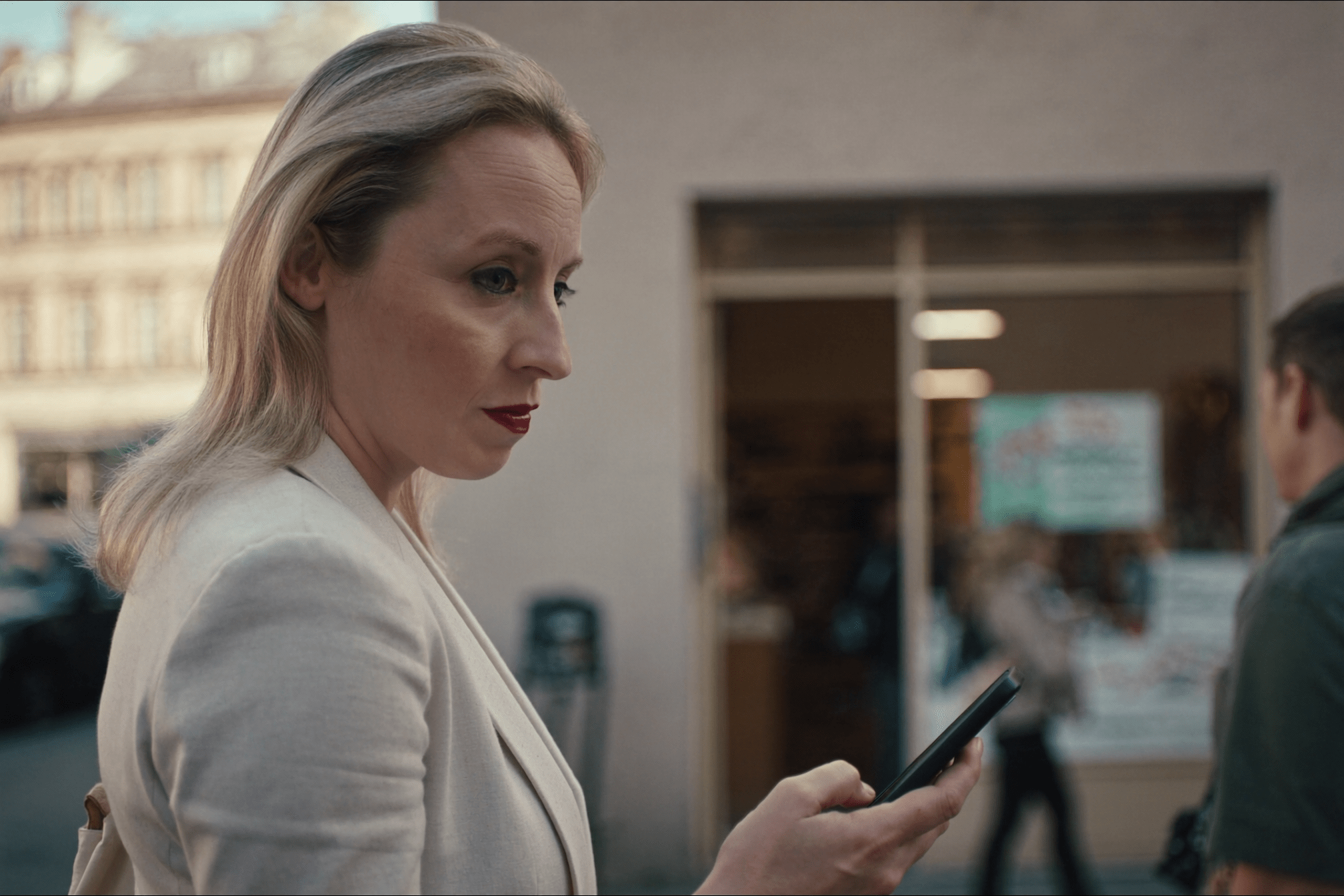 Persona che controlla le recensioni sul telefono prima di entrare in un negozio
